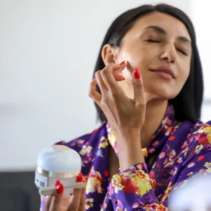 A woman applying face cream