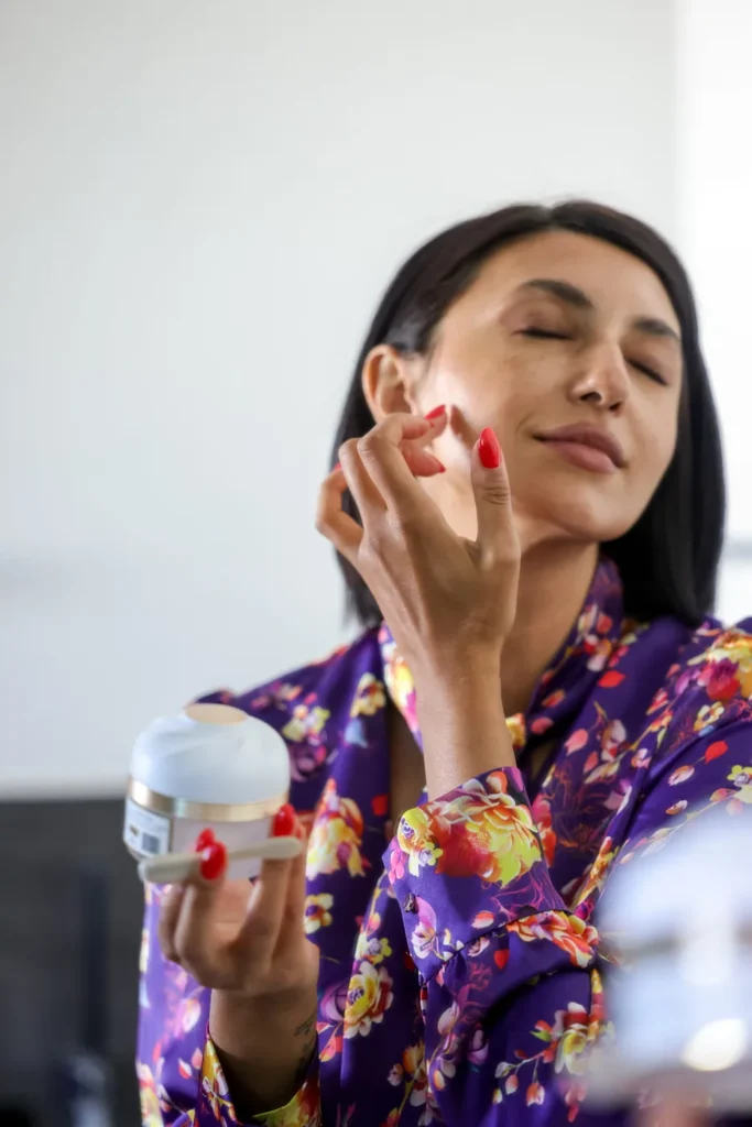 A woman applying face cream